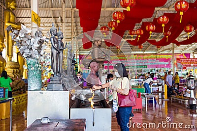 People pray respect and put oil lamp, focus selective at black statue buddha Editorial Stock Photo