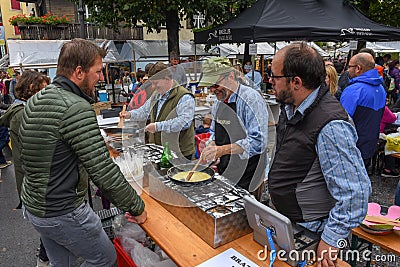 People during the preparation of traditional melted cheese at Engelberg on the Swiss alps Editorial Stock Photo