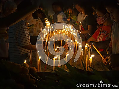 People putting burning incense and candle into pots in Makha Bucha Day Editorial Stock Photo