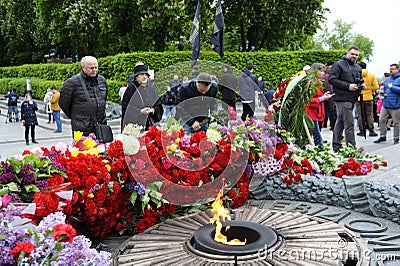 People putting flowers to the Eternal Flame in the Glory park, celebrating the Victory Day Editorial Stock Photo