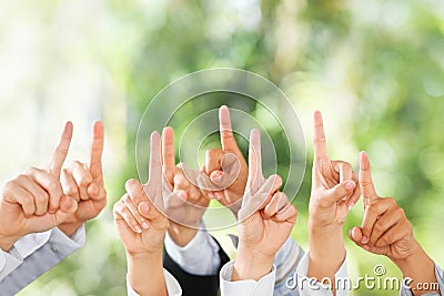 People raise their hands up over green background Stock Photo