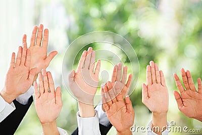 People raise their hands up over green background Stock Photo