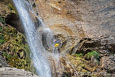 People rappelling in an impressive waterfall Stock Photo