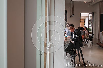 People reading, working, chatting in a comfortable shop serving coffee and tea. Editorial Stock Photo