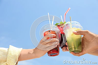 People with refreshing drinks against blue sky Stock Photo