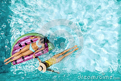 People relaxing on inflatable lilo in hotel pool Stock Photo