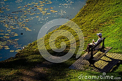 People relaxing near the lake in Nicolae Romanescu Park, Craiova, Romania Editorial Stock Photo