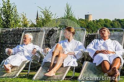 People relaxing on outdoor rest area of sauna Stock Photo
