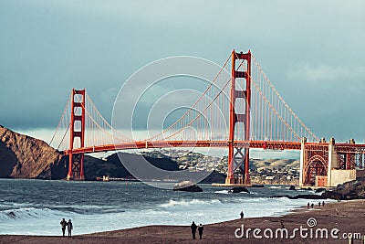 People relaxing and walking on ocean beach near Golden Gate bridge in San Francisco. Editorial Stock Photo