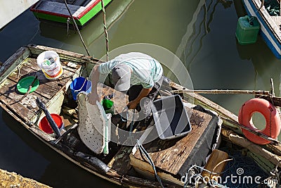 People removing goods from the boats docked on the deck of the SÃ£o Joaquim fair, in Salvador, on a sunny day Editorial Stock Photo