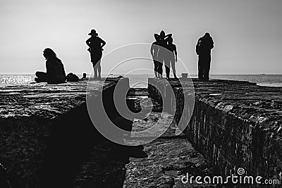 People rest on the pier. Silhouette photo. Stock Photo