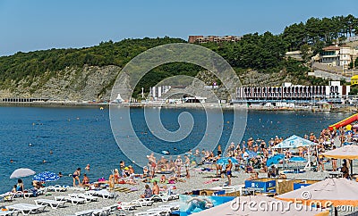 People rest on the rocky beach of the village of Olginka. Beach vacation in early September. Tuapse Editorial Stock Photo