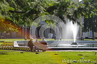 People are resting on the bench near the fountain Editorial Stock Photo