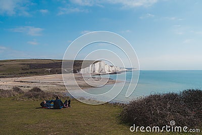 People resting at Seaford Head Nature Reserve and the Cuckmere Haven peacefull seafront beach at the top of the Chalk Cliffs walk Editorial Stock Photo