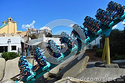 People ride Kraken Roller Coaster at Seaworld Theme Park. Several are screaming. Editorial Stock Photo