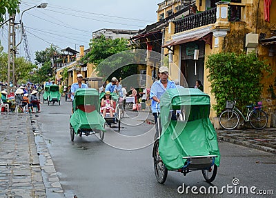 People riding cyclos on the main street in Hoi An, Vietnam Editorial Stock Photo