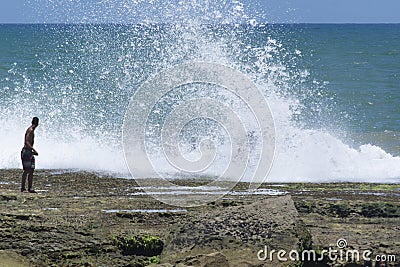 People risking their lives on top of rocks with strong waves Editorial Stock Photo