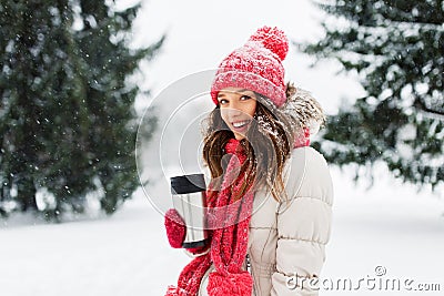 Young woman with hot drink in tumbler in winter Stock Photo