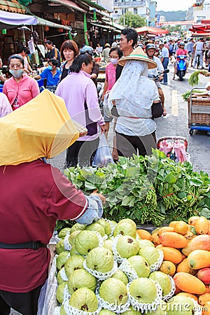 People selling and buying food in a traditional fruit and vegetable market of Taiwan Editorial Stock Photo