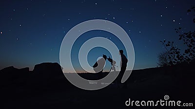 People on shore looking through telescope Stock Photo