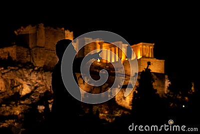People silhouettes in the foreground, with Acropolis night view at the background Stock Photo