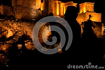 People silhouettes in the foreground, with Acropolis night view at the background Stock Photo