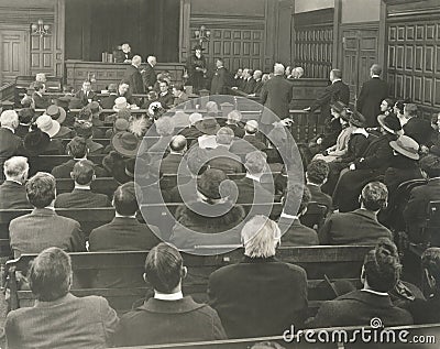 People sitting on benches in courtroom Stock Photo