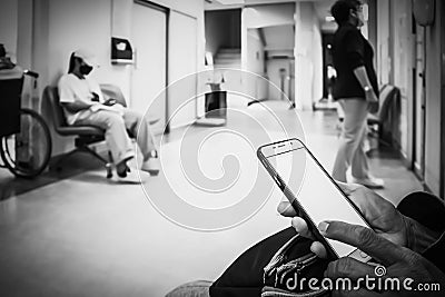 People sitting in front of the examination room and use a smartphones waitting to see a doctor in the hospital Stock Photo