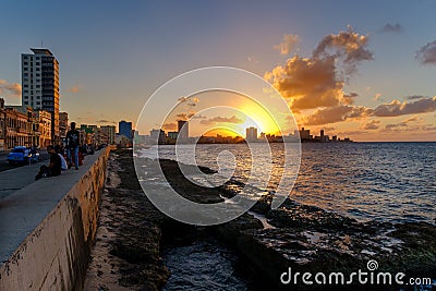 People sitting on the malecon seawall in Havana during a beautiful sunset Editorial Stock Photo