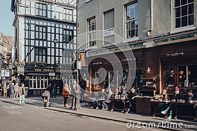 People sitting at the outdoor tables of Cafe Boheme in Soho, London, UK Editorial Stock Photo