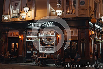 People sitting at the outdoor tables of The Crown pub on Seven Dials in Covent Garden, London, UK Editorial Stock Photo