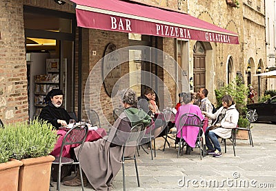 People sitting in a small cafe outside in the medieval town of Montepulciano Editorial Stock Photo