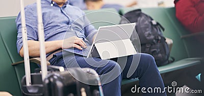 People sitting and working on tablet when waiting for delayed flight Stock Photo