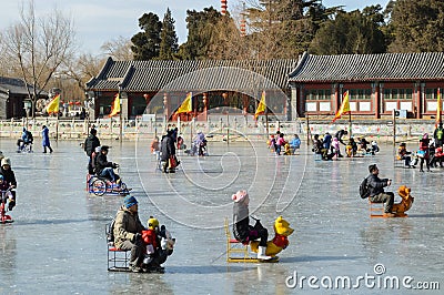 People skating and sliding on sledges on frozen Houhai lake in Beijing, China Editorial Stock Photo