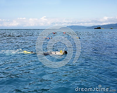 People snorkeling in open blue sea Stock Photo