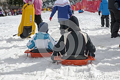 Wintertime: time to have fun in a ski resort. Snow, mountain, tobogganing. Stock Photo