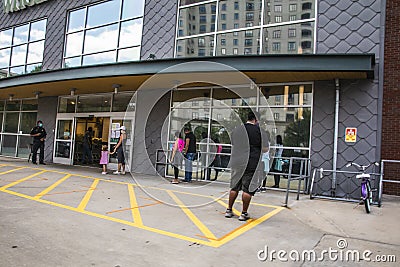 People social distancing during the covid-19 pandemic while waiting Editorial Stock Photo