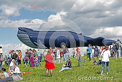 People stand against the background of a huge whale kite at the kite festival in the Park Tsaritsyno in Moscow Editorial Stock Photo