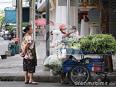 People stand next to a mobile food cart Editorial Stock Photo