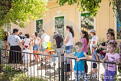 People stand in queue at the zoo. Street Editorial Stock Photo