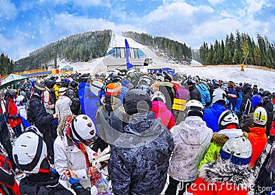 People stand before ski lift in queue in Bukovel Editorial Stock Photo