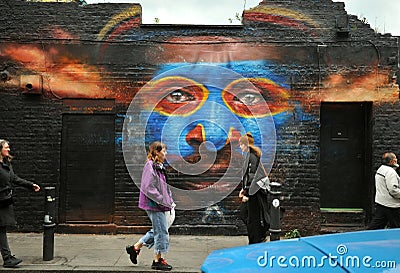 People on the streets of Brick Lane with famous graffiti, East London Editorial Stock Photo