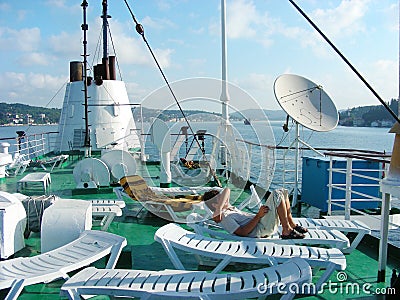 People sunbathe on sunbeds on the deck of the ship Editorial Stock Photo