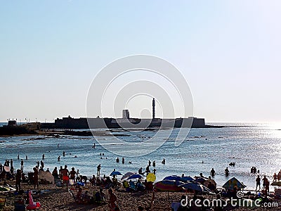 People sunbathing at sunset on the beach of La Caleta in the bay of Cadiz, Andalusia. Spain. Editorial Stock Photo