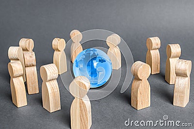 People surrounded a Globe world planet earth. Cooperation and collaboration of people around the world. Outsourcing and joint work Stock Photo