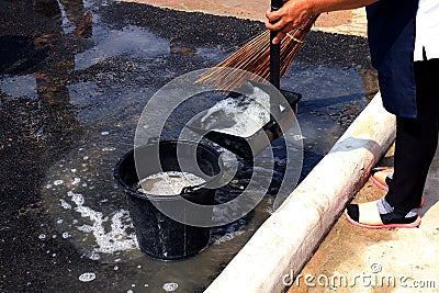 People are sweeping dirty water at ground streets, cleaner floor, housemaid, housekeeper, homemaker, maidservant, maid Stock Photo