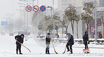 People sweeping the snow on the road Editorial Stock Photo