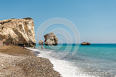 People swim at the beach next to a popular Aphrodite Rock in Cyprus Editorial Stock Photo