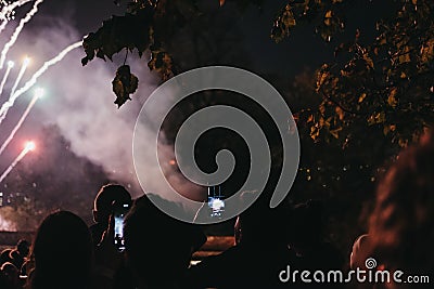 People taking photo of fireworks on mobile phone during Guy Fawkes Night yearly celebration in Alexandra Palace, London, UK.. Editorial Stock Photo