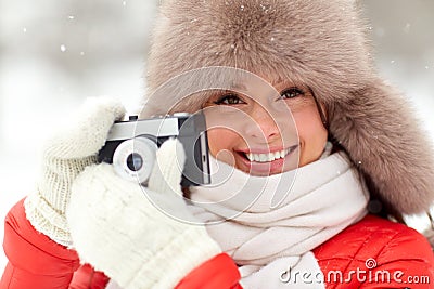 Happy woman with film camera outdoors in winter Stock Photo